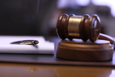 Photo of a gavel next to pen resting on a legal tablet representing the law firm of Donnelly Minter & Kelly, LLC